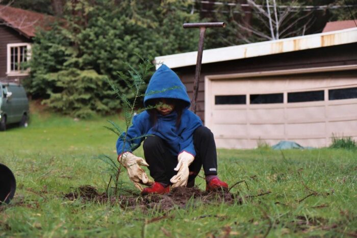 Young girl learns about restoration in a planting effort joined by the League at Hartsook Creek
